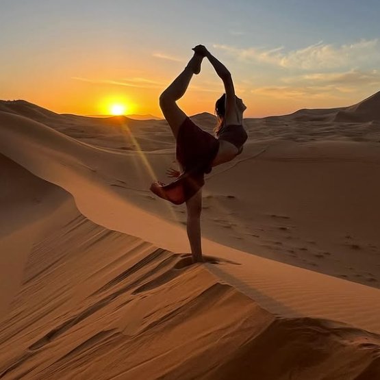 Mary Lou in einer Yoga-Haltung auf einer Sanddüne im Sonnenuntergang